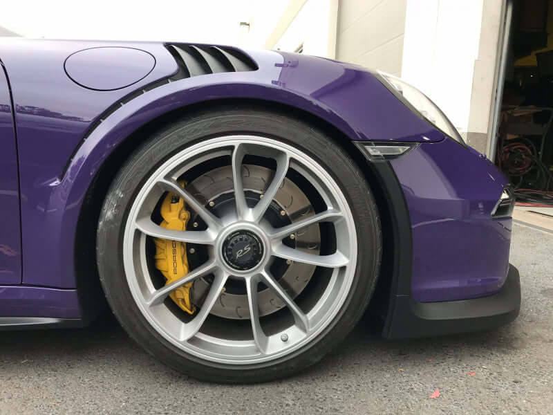 Front view of a purple car showcasing AP Racing 2-piece Competition J Hook disc and yellow brake caliper.