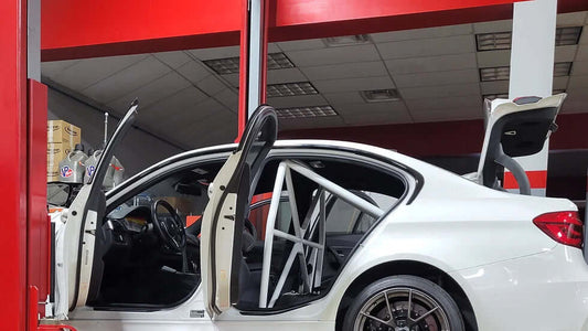 WPM F80 M3 Clubsport Half Cage installed in a white BMW M3, showing the interior and roll cage structure.