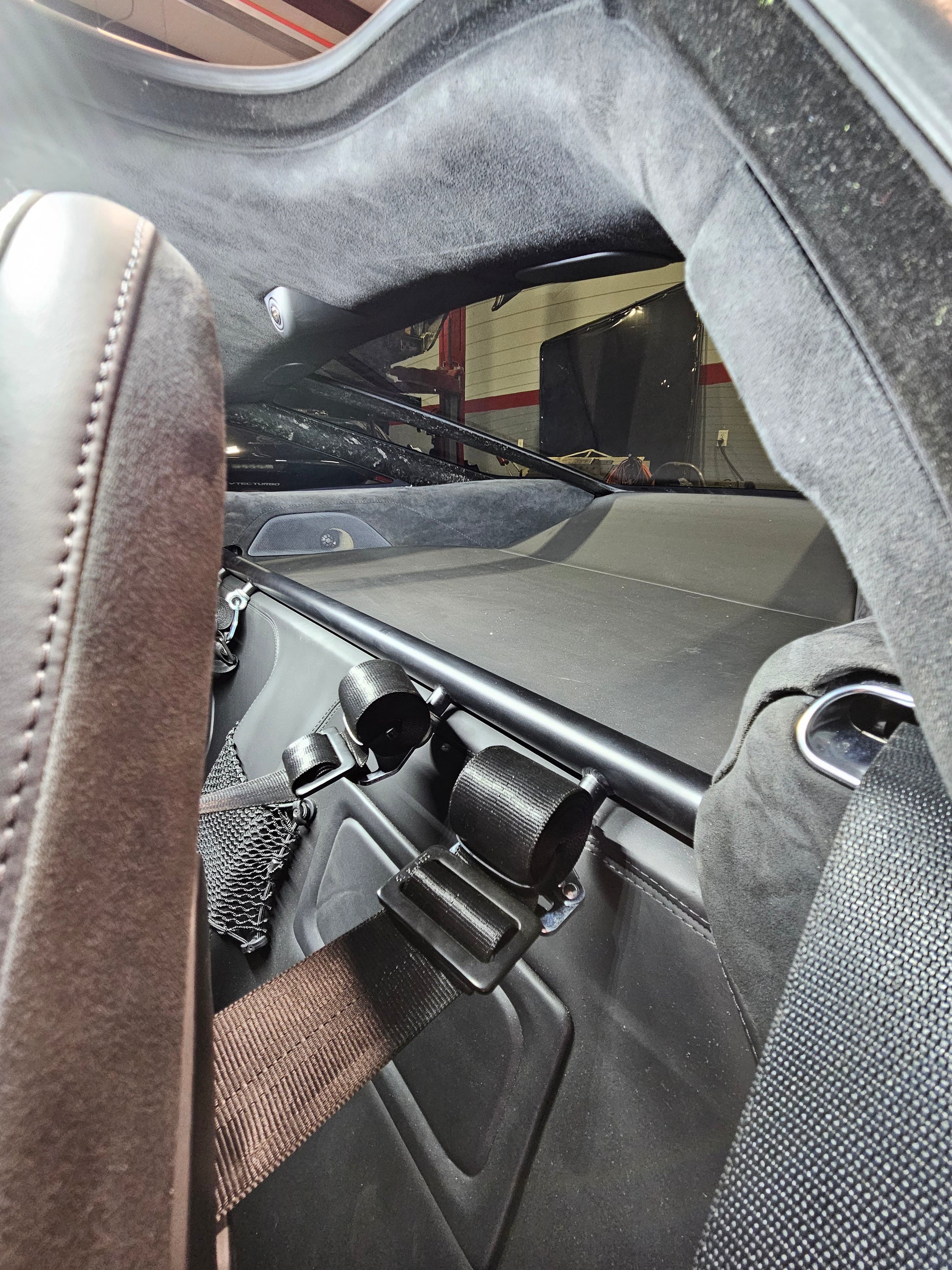 Close-up view of Mclaren 720S Coupe harness package showcasing harness bar and under seat brackets installation.