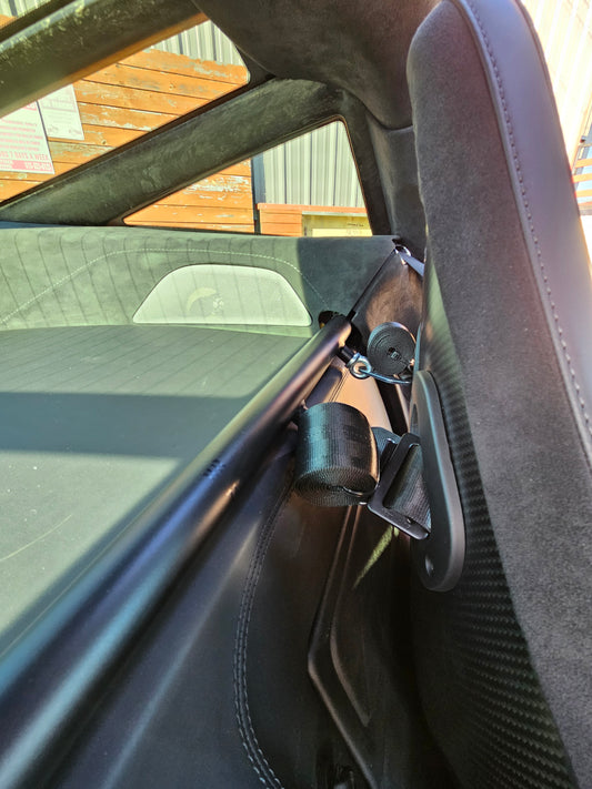 Close-up view of the McLaren 720S Coupe harness bar with under seat brackets, designed for 6pt racing harnesses.