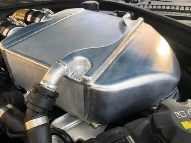 PWR F80 M3 intercooler featuring handcrafted TIG welds for optimal heat dissipation under the hood of a BMW.
