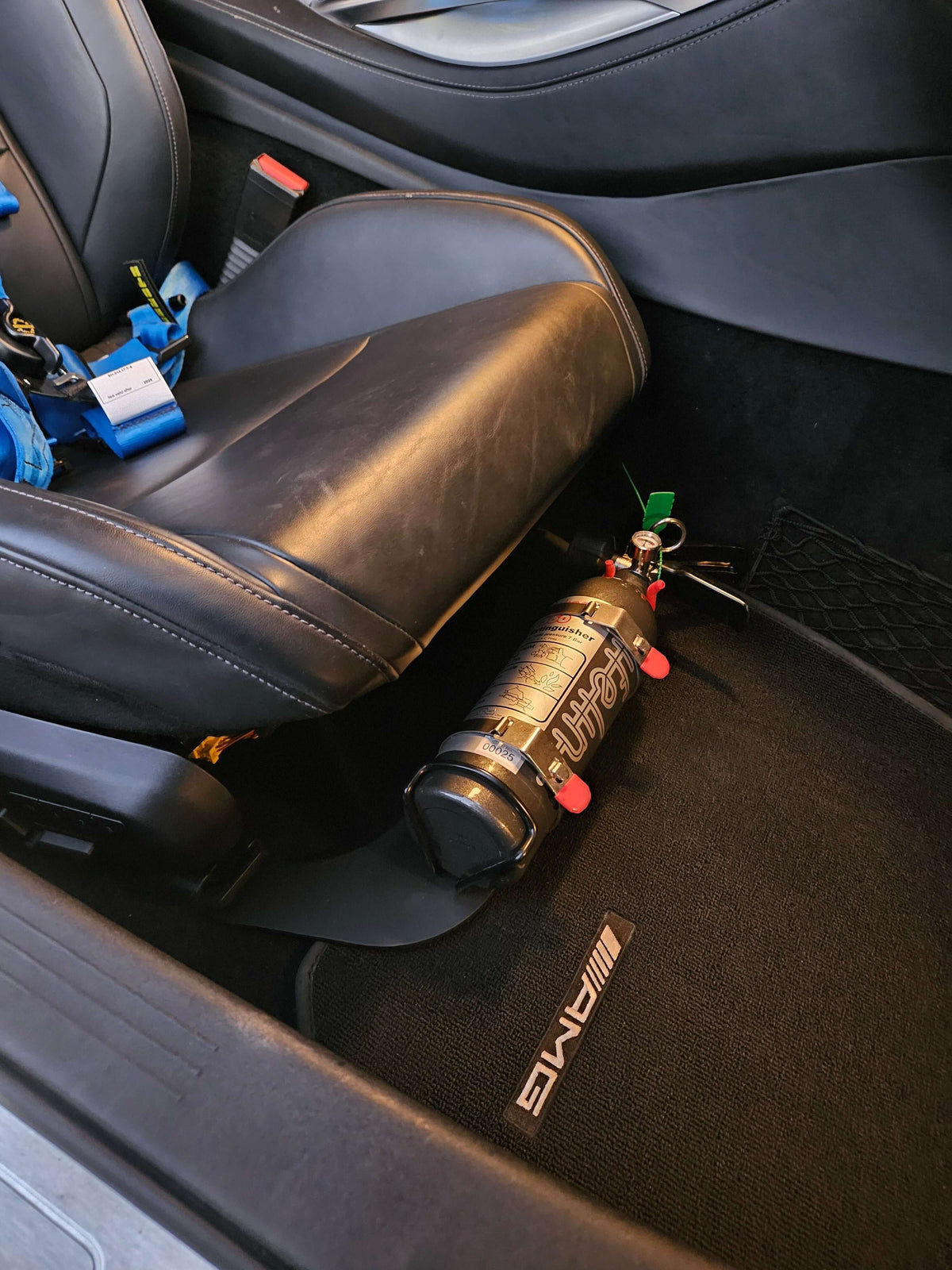 AMG GT underseat fire bottle mount showcasing 3lb Lifeline extinguisher securely installed in car interior.