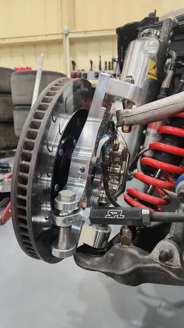 Louis Giglotti Racing C5/C6 adjustable drop spindles with SPL HD toe link on a Corvette suspension setup.