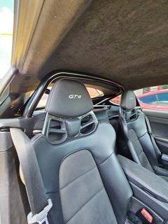 Interior view of Porsche GT4 seats with roll bar, showcasing premium design and fitment in a Cayman.